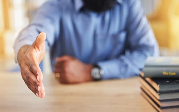 A close-up photo of two hands shaking over a contract. The background is blurred, showing office workers in a modern workspace. The lighting is warm and inviting, emphasizing the importance of agreement and collaboration.