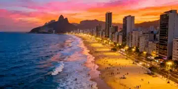 Vista aérea vibrante de uma cidade litorânea brasileira ao pôr do sol, com praias movimentadas e edifícios modernos, simbolizando o crescimento do turismo nacional em 2026.